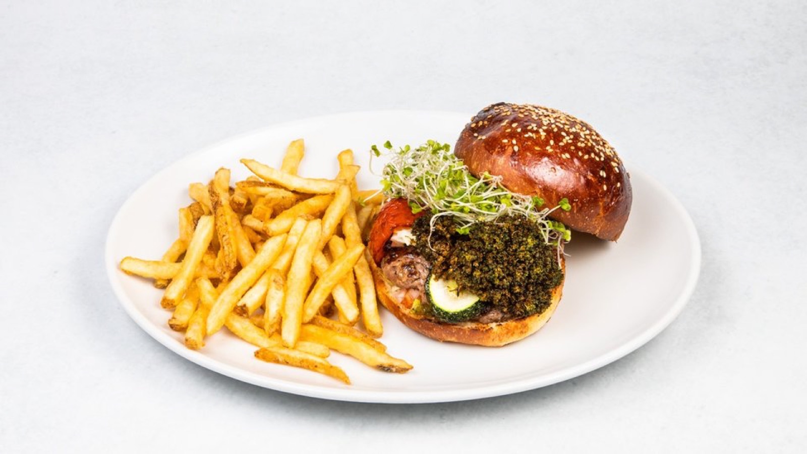 白い背景に置かれた「393バーガー」。バンズ、パティ、季節野菜が層になった看板の一品