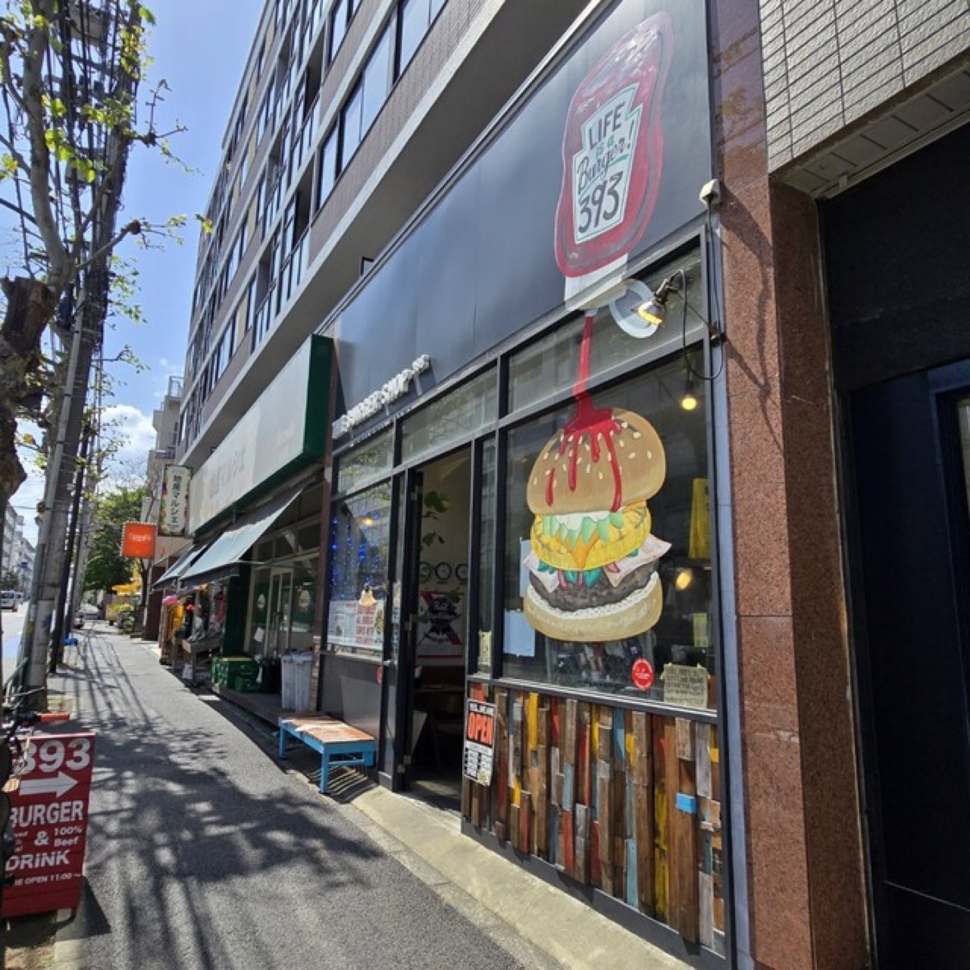 笹塚の店頭。「393 BURGER」「OPEN 11:00」の立て看板とハンバーガーのウォールアート